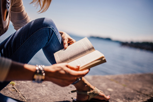Person reading about pollution at the beach